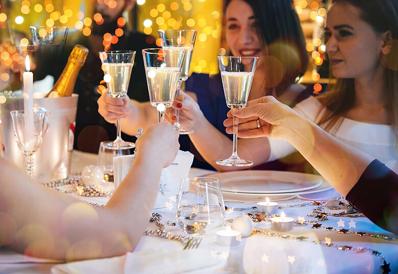 Gruppe feiernde Menschen stossen mit Glas Sekt an