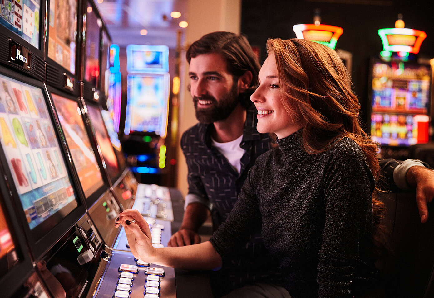 Frau und Mann spielen an den Spielautomaten im Casino