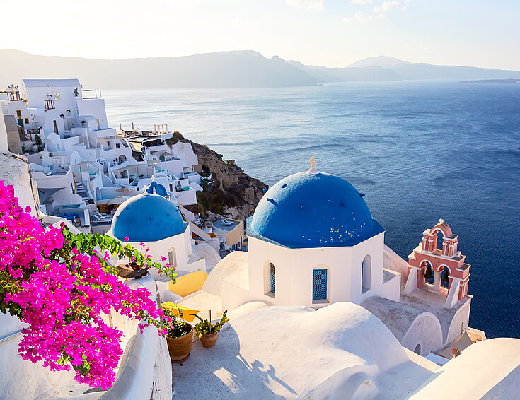  famous-santorini-iconic-view-blue-domes-traditional-white-houses-with-bougainvillea-flowers-oia-village-santorini-island-greece